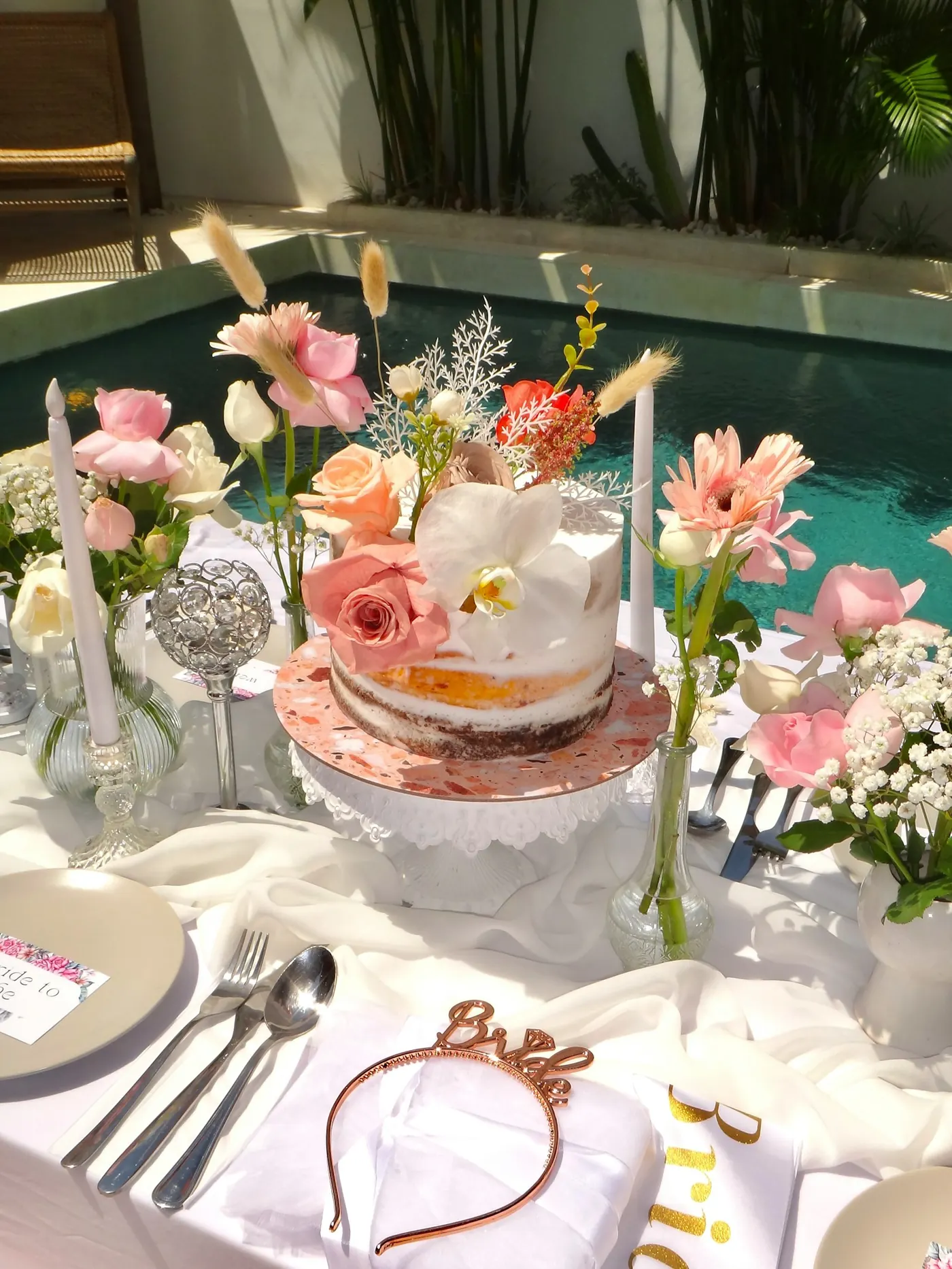 Liebevoll gedeckter Tisch mit Blumen, Torte und einem Bride-Haarreif