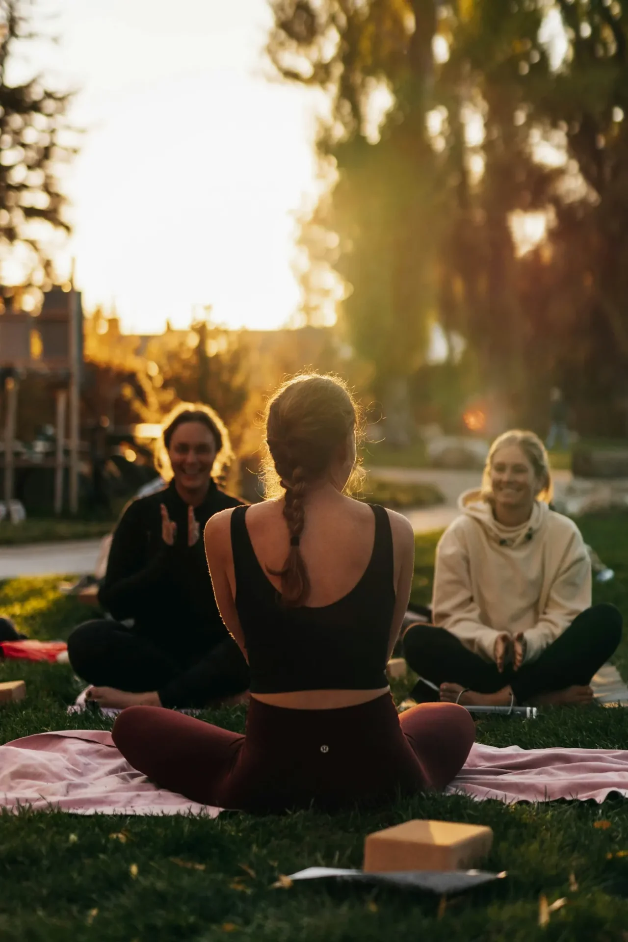 Kleine Runde sitzt im warmen Abendlicht im Kreis auf Yogadecken