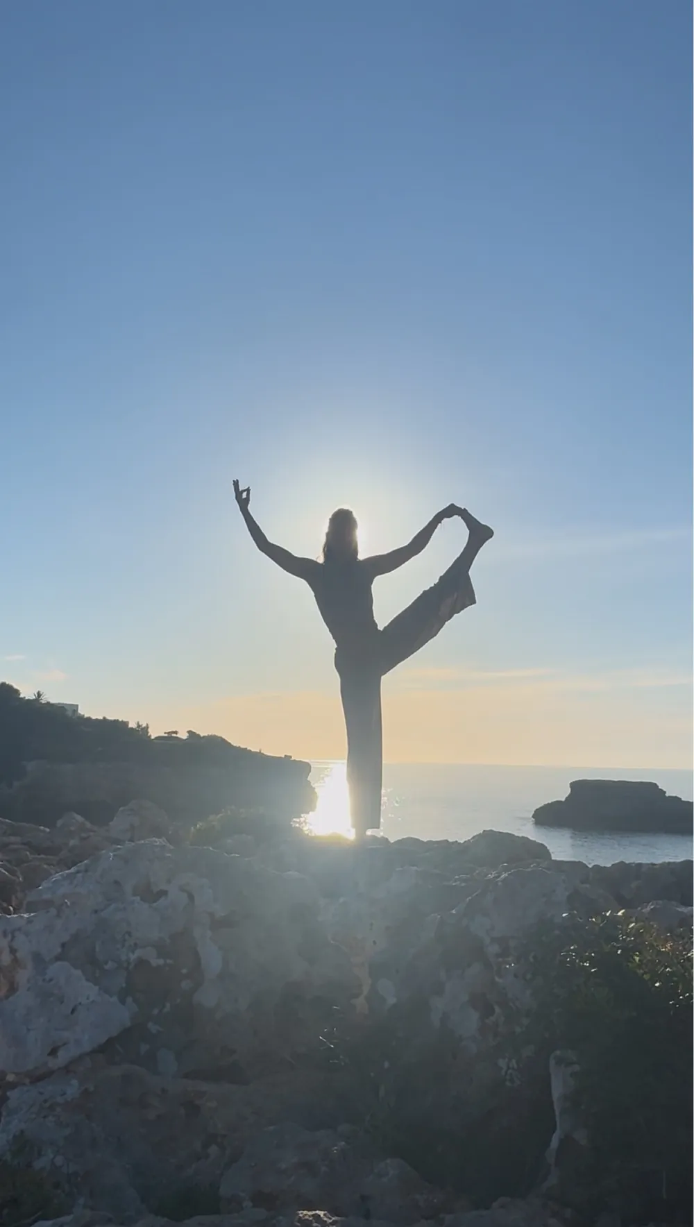 Yogapose im Gegenlicht der Sonne über dem Meer